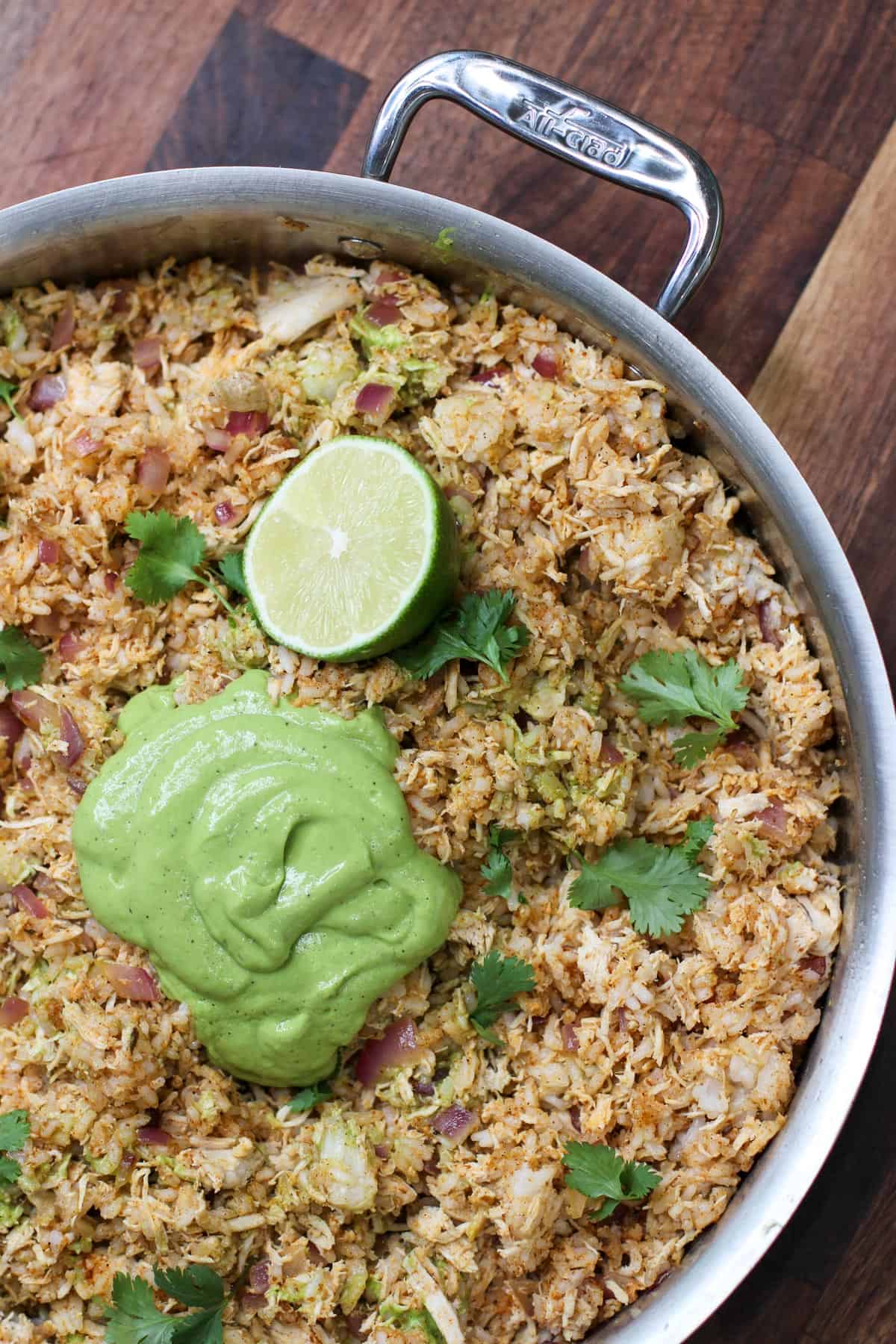 Fresh fish taco filling with lime and avocado sauce in a metal serving dish.