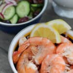 A bowl of peel & eat shrimp seasoned with Old Bay and served with lemon wedges. The shrimp are plump, pink, and perfectly cooked.