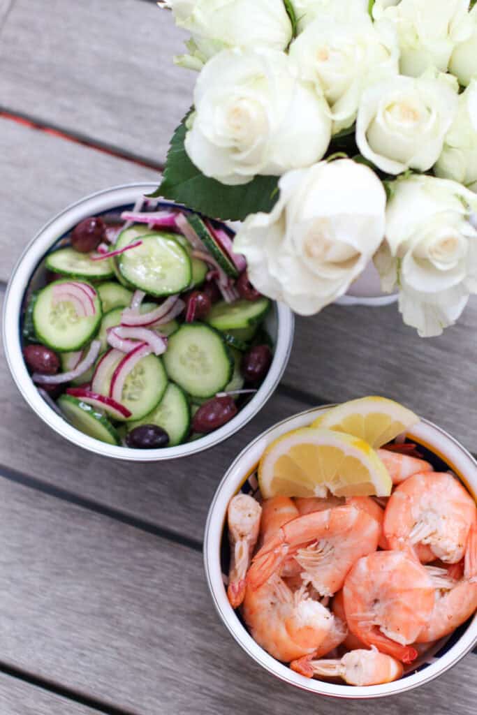 A bowl of peel & eat shrimp seasoned with Old Bay and served with lemon wedges. The shrimp are plump, pink, and perfectly cooked.