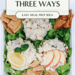 Close up of a chicken salad trio on a white platter, showing creamy texture, all atop a bed of greens served with a variety of crackers.. The platter is displayed on a picnic blanket.