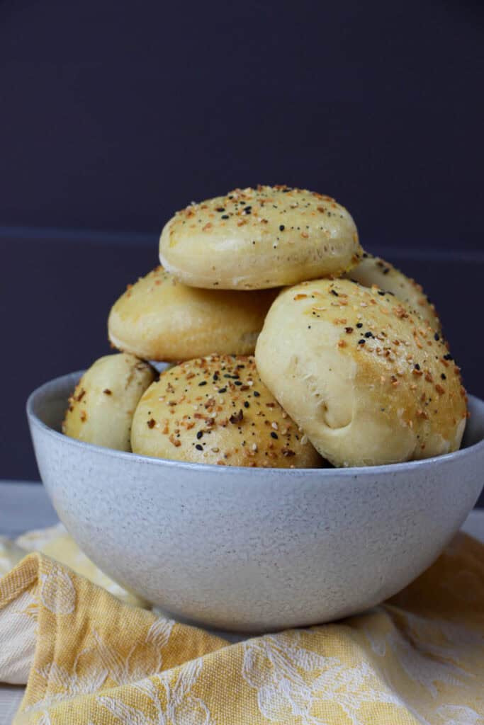 Homemade fluffy everything but the bagel burger buns stacked in a bowl.