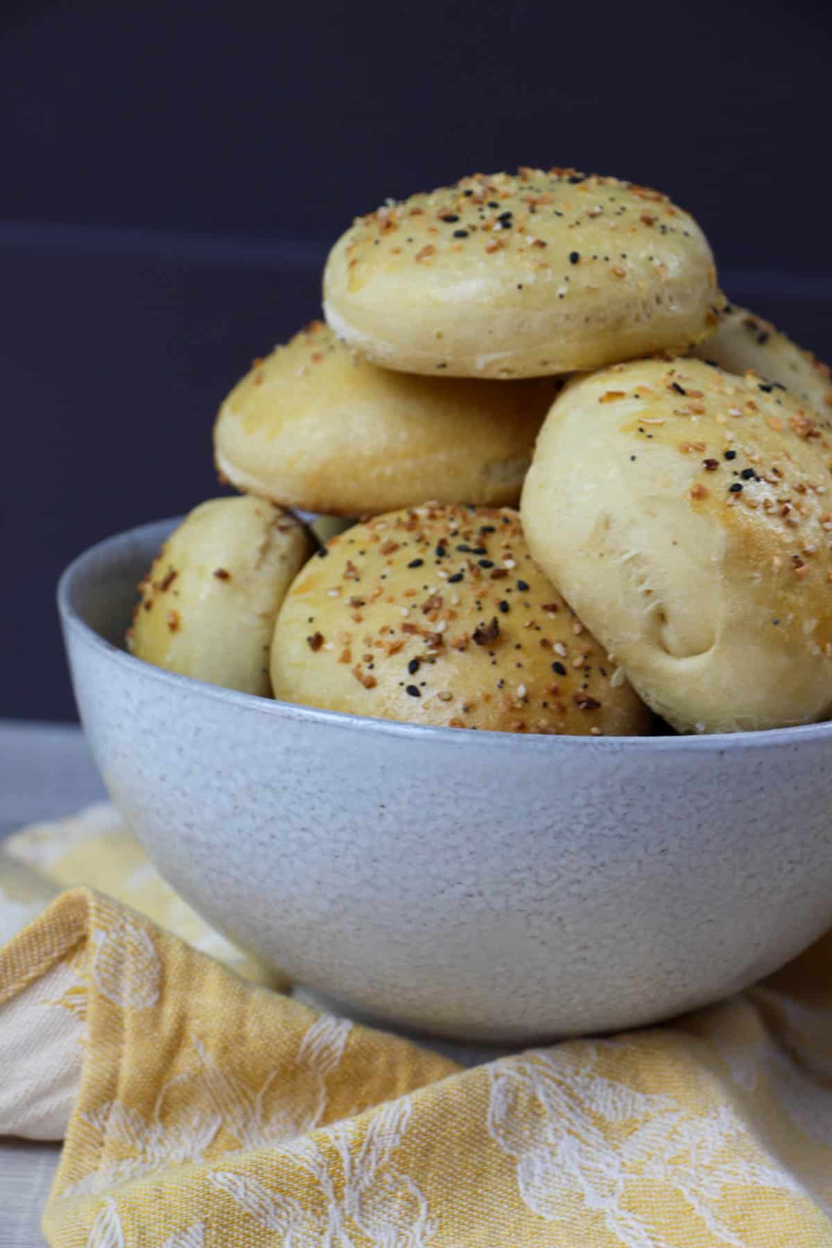 Homemade fluffy everything but the bagel burger buns stacked in a bowl.