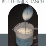Herbed buttermilk ranch being poured from a spoon into a glass measuring cup.