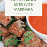 Plate of pizza burger bites with marinara dipping sauce, garnished with fresh parsley.