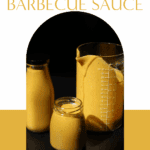 Homemade Carolina Gold barbecue sauce in glass jars and a measuring beaker, showcasing its smooth, creamy texture and rich golden color against a dark background.