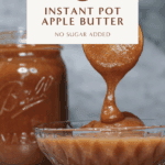 A spoon drizzling thick homemade apple butter into a glass bowl beside of mason jar of apple butter, set against a gray marble background.