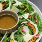 A fall salad featuring roasted delicata squash rings, shaved fennel, arugula, pomegranate seeds, and toasted pumpkin seeds drizzled with a citrus vinaigrette.
