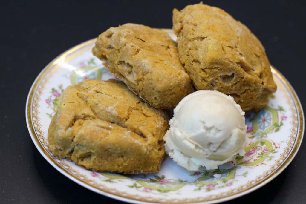 Mini sweet potato biscuits on a plate served with whipped maple butter - golden, fluffy, and perfect for entertaining.