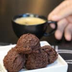 Brownie batter protein bites stacked in a glass bowl, made with cocoa powder, almond flour, and chocolate protein powder.