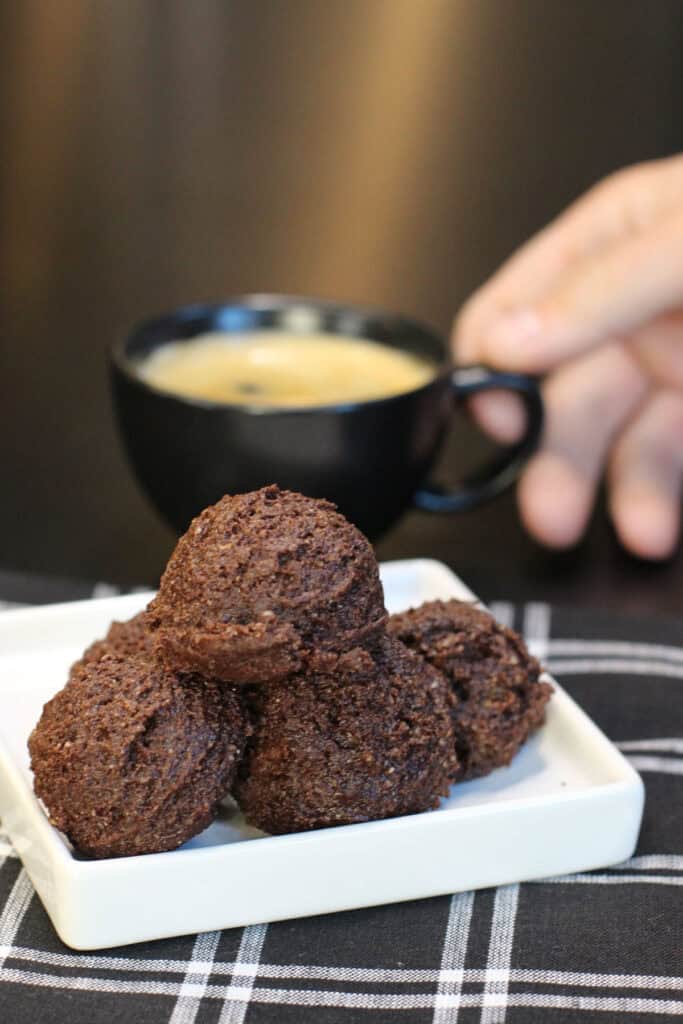 Brownie batter protein bites stacked in a glass bowl, made with cocoa powder, almond flour, and chocolate protein powder.