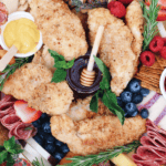 Crispy gluten-free chicken fingers served with homemade honey mustard on a grazing board.