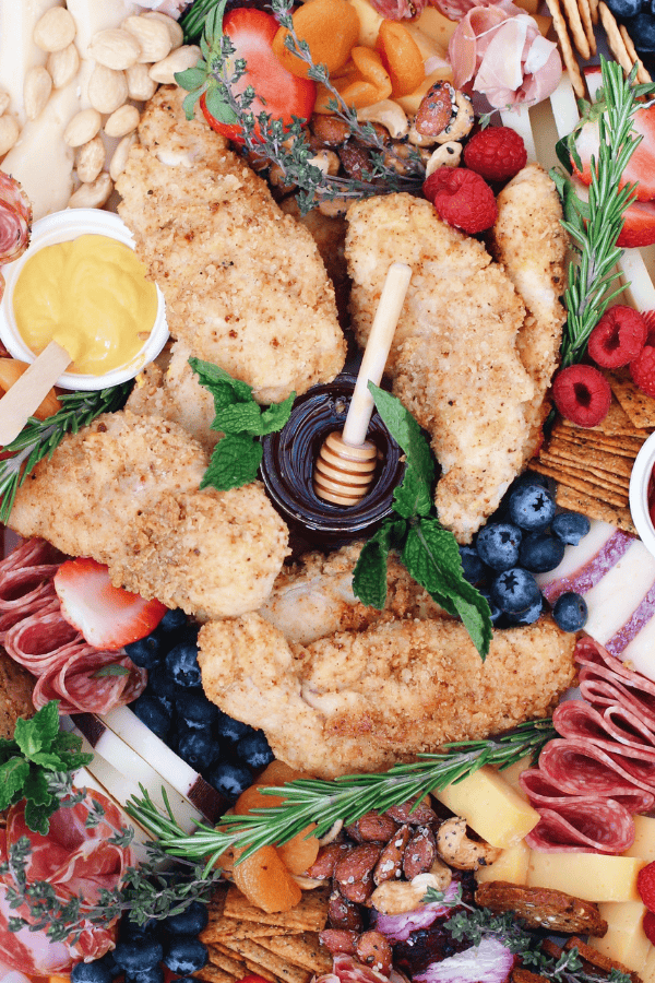 Crispy gluten-free chicken fingers served with homemade honey mustard on a grazing board.