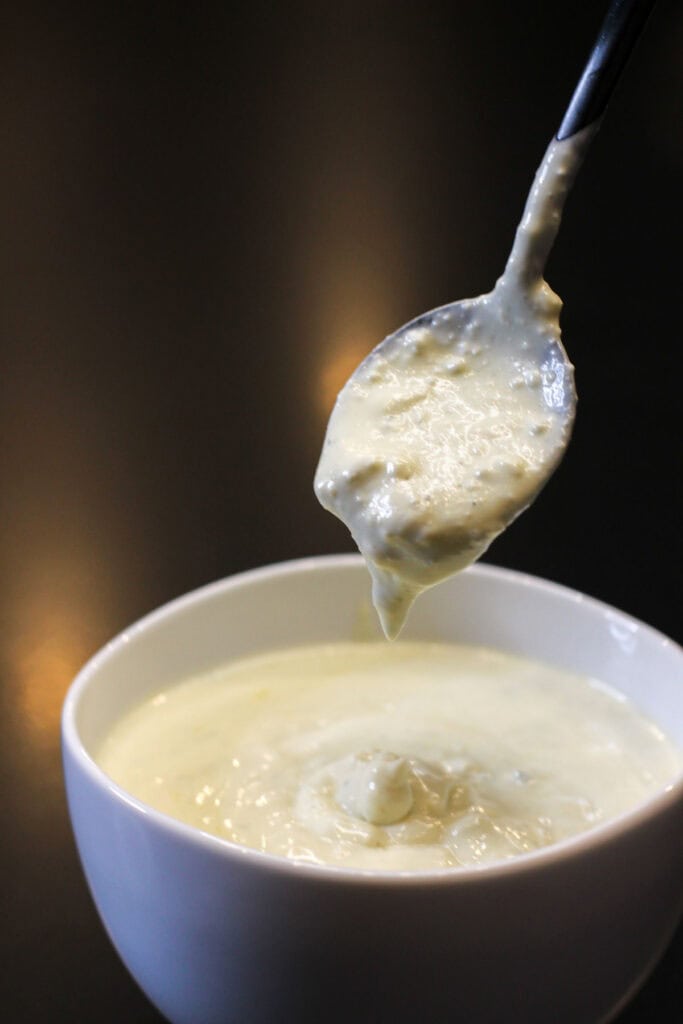 Creamy homemade blue cheese dressing in a white bowl with spoon