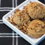 No-bake maple pecan protein bites made with almond flour, chopped pecans, maple syrup, and cinnamon, arranged on a white serving dish.