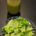 French butter lettuce salad with Dijon vinaigrette served alongside a jar of homemade dressing
