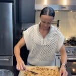Caitlin preparing homemade peanut butter trail mix with maple, toasted nuts, crispy rice cereal, and Redmond Real Salt on a sheet pan in a home kitchen.