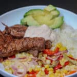 Sheet pan chili lime beef taco bowl with rice, roasted peppers and corn, avocado, and chili lime sour cream.